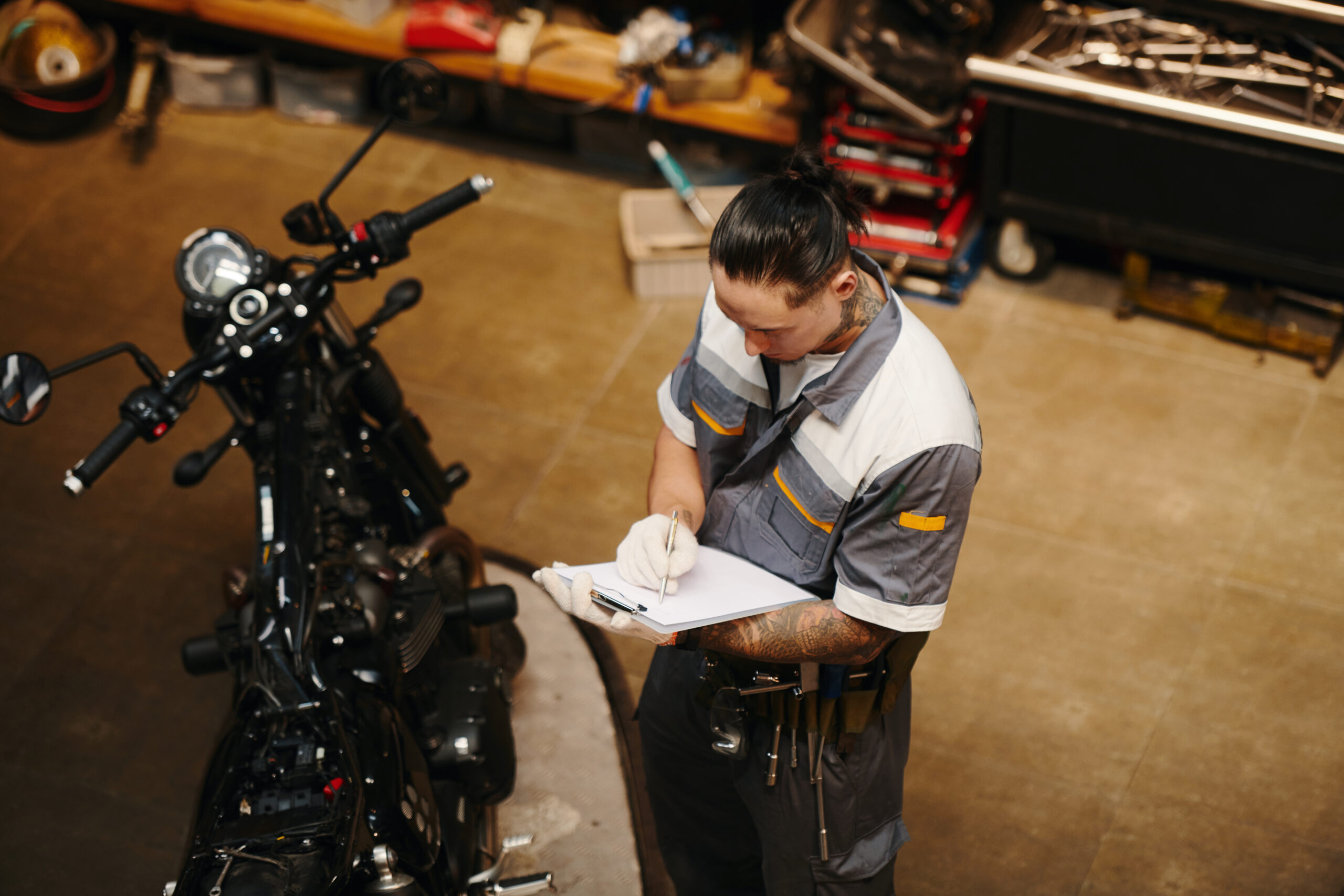 mechanic examining broken motorcycle