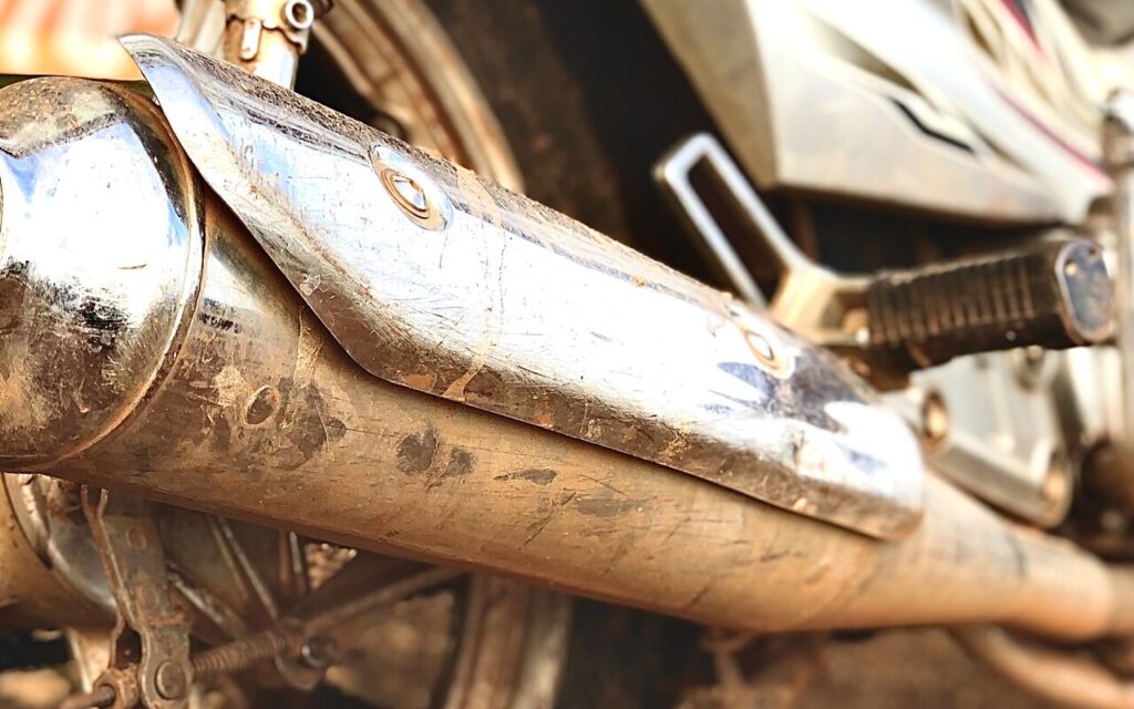 Gros plan sur l'échappement chromé d'une moto, la source du bruit désormais visée par les radars sonores en France Source : Wikimedia Commons (Exhaust pipe), auteur Nkpelawuni, licence CC BY-SA 4.0.
