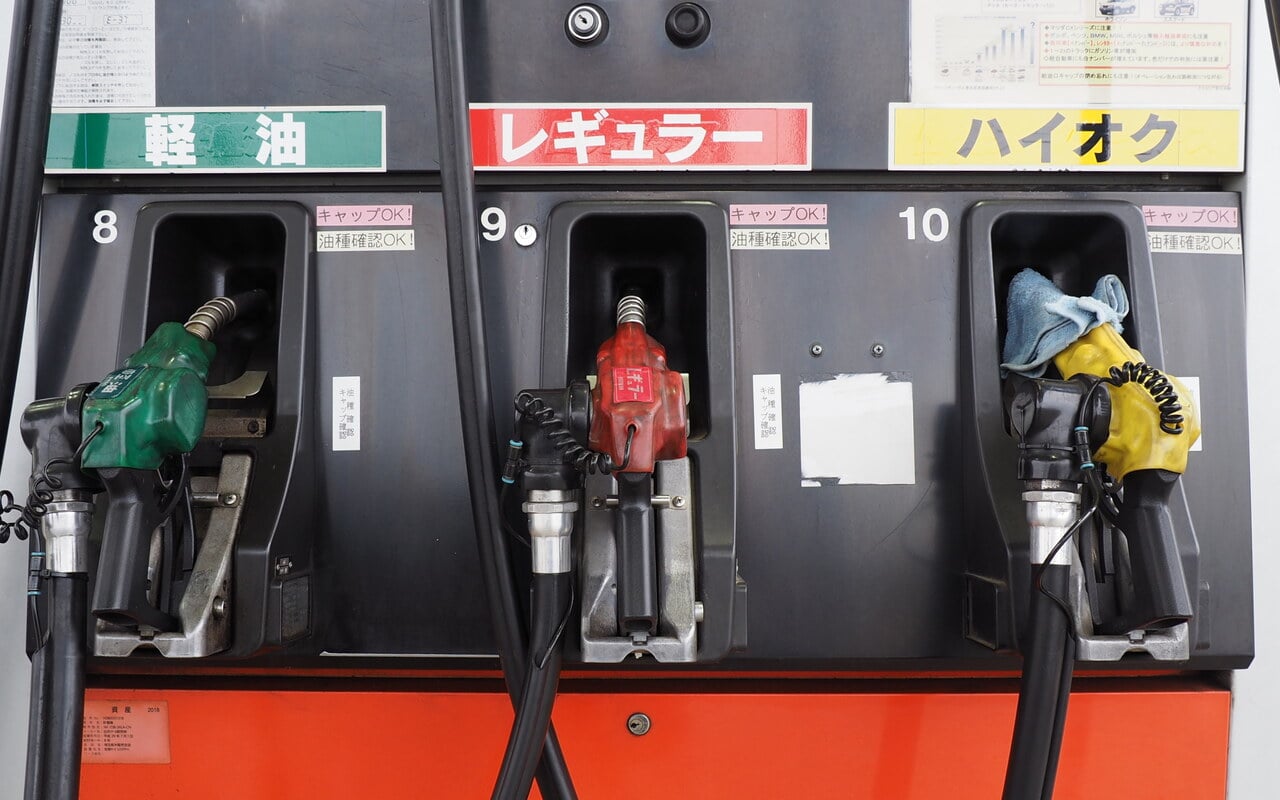 Trois pistolets colorés d'un distributeur de carburant dans une station-service