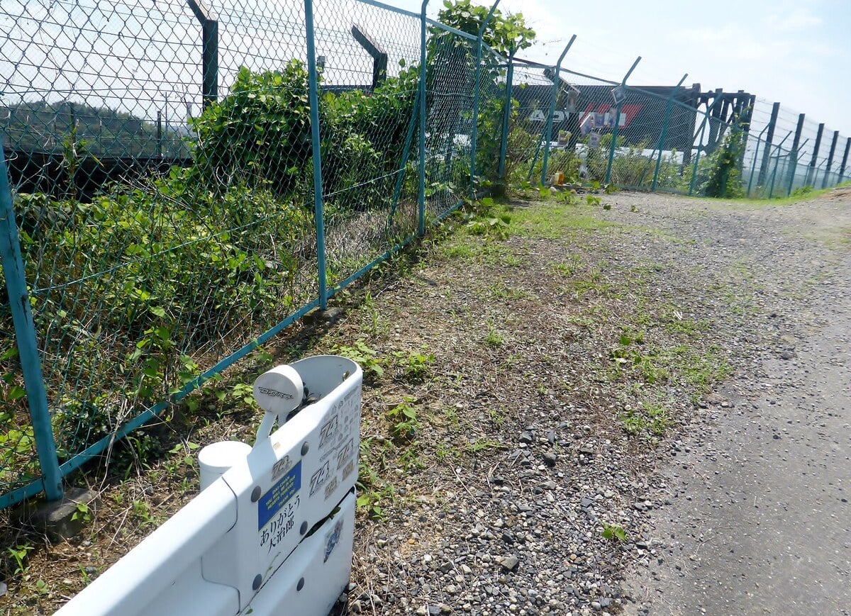 Rail de sécurité blanc couvert d'autocollants au numéro 74 le long du grillage du circuit de Suzuka