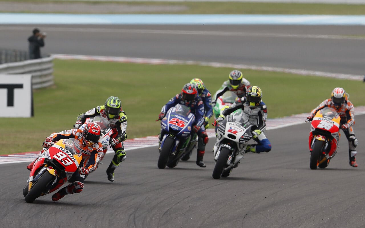 Groupe de motos MotoGP en pleine courbe sur circuit, la machine de tête très inclinée
